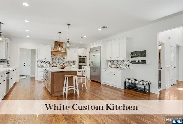 21 Flintlock Rd, Montvale, NJ 07645 - kitchen featuring a kitchen island, visible vents, tasteful backsplash, a breakfast bar, and stainless steel appliances