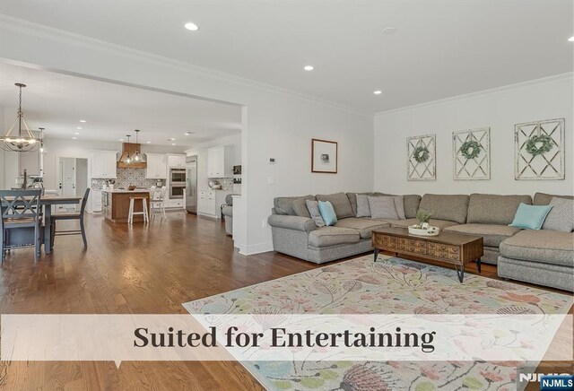 21 Flintlock Rd, Montvale, NJ 07645 - living room with an inviting chandelier, recessed lighting, ornamental molding, and dark wood finished floors