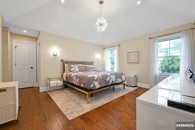 bedroom with dark wood-style floors, vaulted ceiling, a notable chandelier, and baseboards