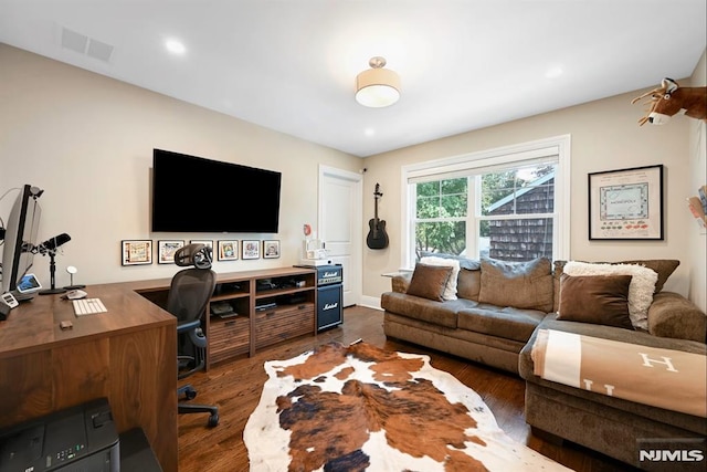 office with visible vents and dark wood-style floors