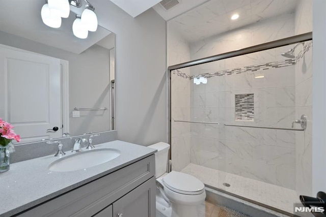bathroom featuring vanity, toilet, visible vents, and a stall shower