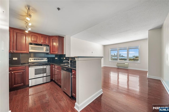 kitchen with dark countertops, stainless steel appliances, open floor plan, backsplash, and dark wood-style floors