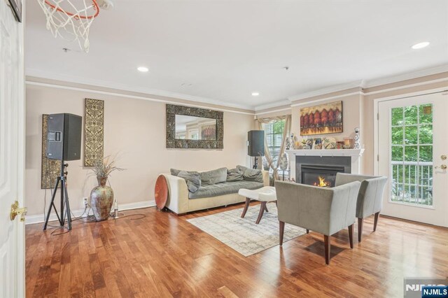 150 Blue Heron Dr, Secaucus, NJ 07094 - living area featuring wood finished floors, healthy amount of natural light, ornamental molding, a glass covered fireplace, and baseboards