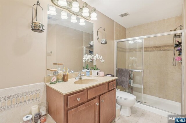 150 Blue Heron Dr, Secaucus, NJ 07094 - full bath featuring toilet, vanity, a stall shower, tile patterned floors, and wainscoting