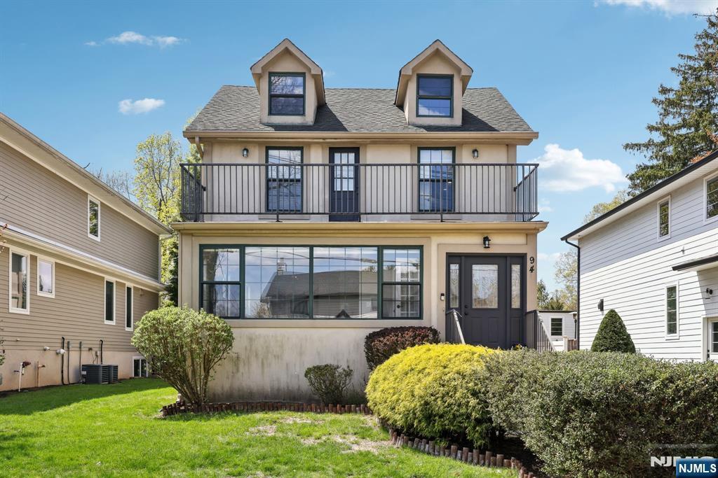 94 Westervelt Pl, Cresskill, NJ 07626 - view of front of home with roof with shingles, stucco siding, a front yard, and a balcony