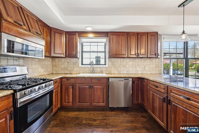 kitchen with light stone counters, a sink, and appliances with stainless steel finishes