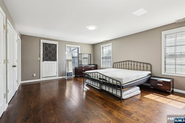 bedroom featuring baseboards, wood finished floors, and visible vents