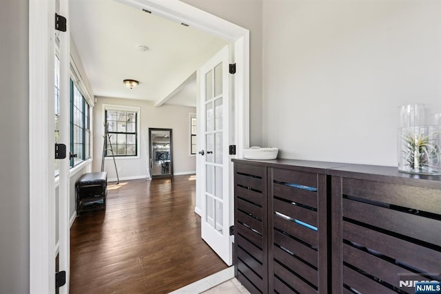 hallway featuring french doors, baseboards, and wood finished floors