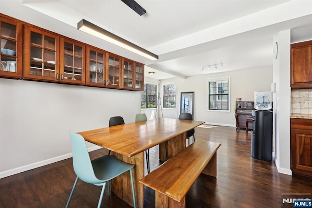 dining room with dark wood-type flooring and baseboards