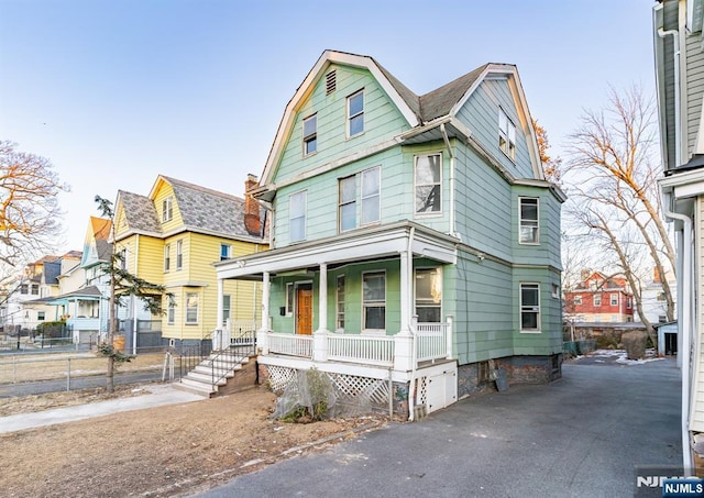 victorian home with a porch and fence