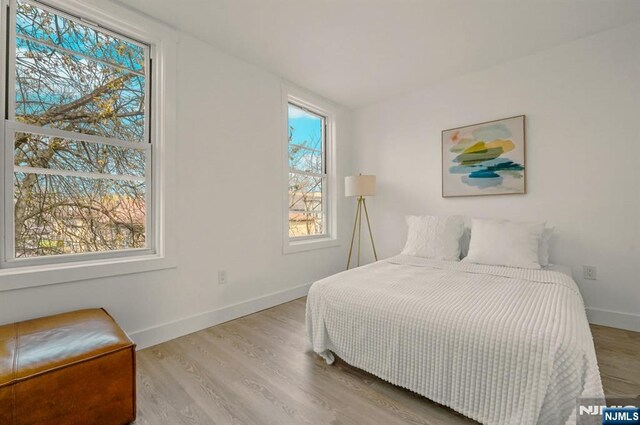 bedroom featuring baseboards and wood finished floors