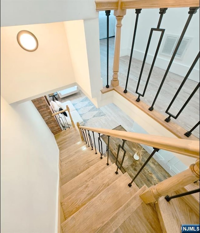 stairs featuring wood finished floors and visible vents