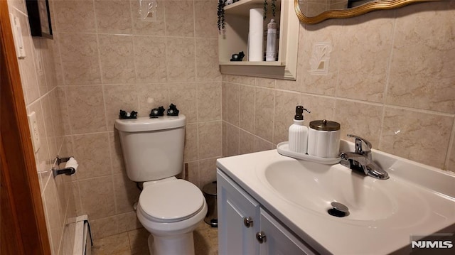 half bathroom featuring a baseboard radiator, tile walls, toilet, and vanity