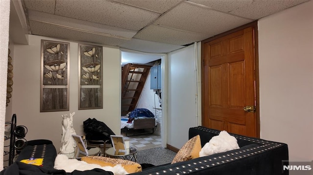 interior space with a paneled ceiling and stairs