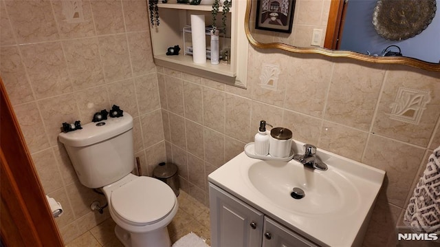 bathroom with tile walls, toilet, and vanity