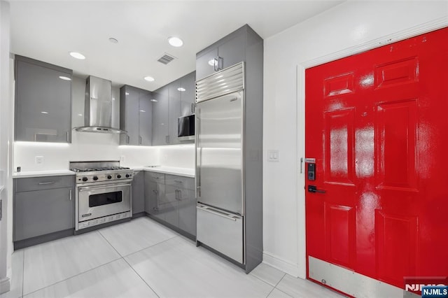 7400 River Rd Unit 431, North Bergen, NJ 07047 - kitchen with wall chimney range hood, high quality appliances, gray cabinetry, light tile patterned floors, and light countertops