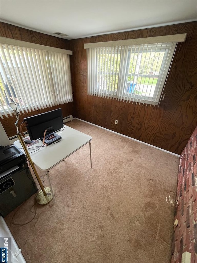 carpeted home office featuring wood walls and visible vents