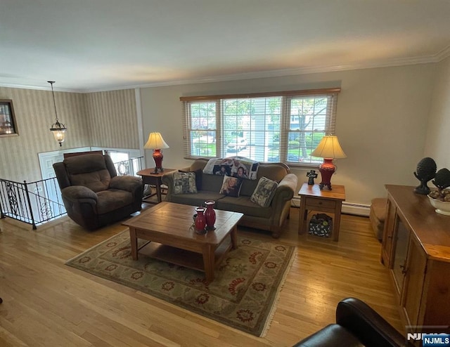 living area with baseboards, ornamental molding, a baseboard radiator, and wood finished floors