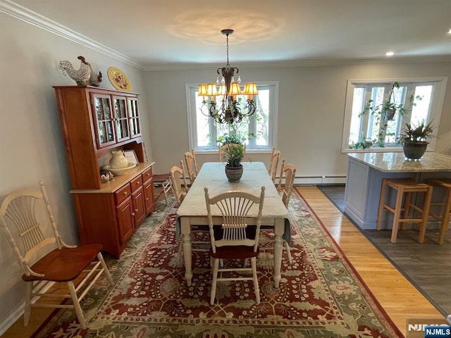 dining area featuring ornamental molding, baseboard heating, dark wood-style flooring, and a chandelier
