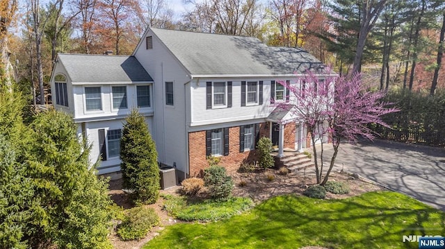 38 Farley Pl, Allendale, NJ 07401 - view of front of house featuring central air condition unit, a front lawn, driveway, brick siding, and roof with shingles