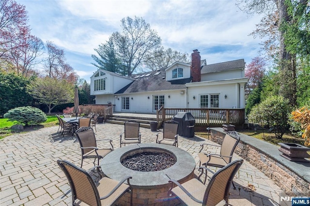 38 Farley Pl, Allendale, NJ 07401 - back of property with a patio area, a chimney, outdoor dining space, a fire pit, and a wooden deck