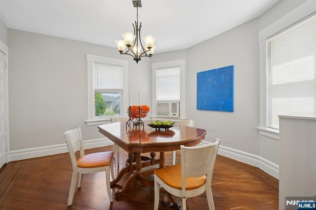 dining area with wood finished floors, a notable chandelier, and baseboards
