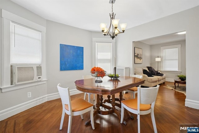 dining area with cooling unit, dark wood-style floors, an inviting chandelier, and baseboards