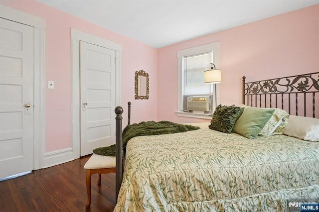 bedroom featuring cooling unit, wood finished floors, and baseboards