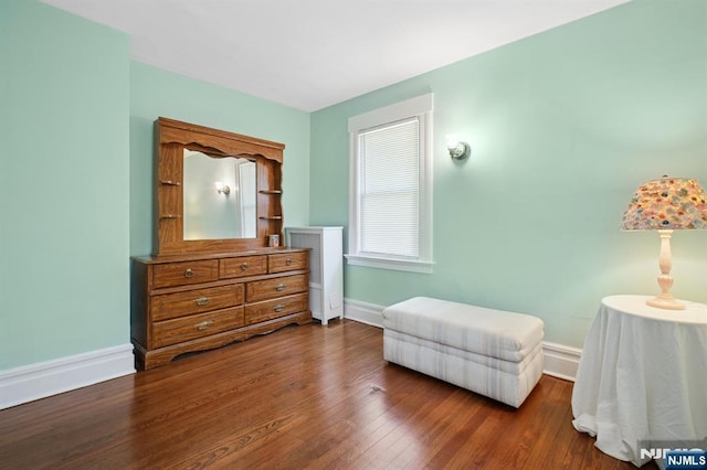 living area featuring baseboards and dark wood-type flooring