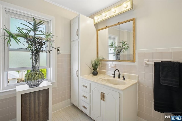bathroom featuring tile patterned floors, tile walls, a wealth of natural light, and vanity