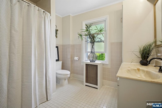 bathroom with tile patterned floors, toilet, crown molding, and tile walls