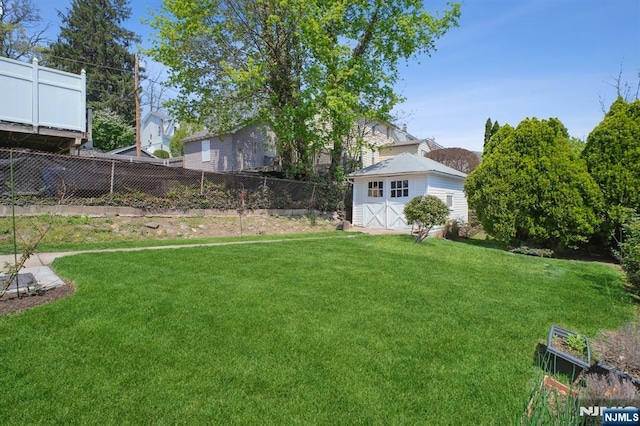 view of yard with fence and an outdoor structure