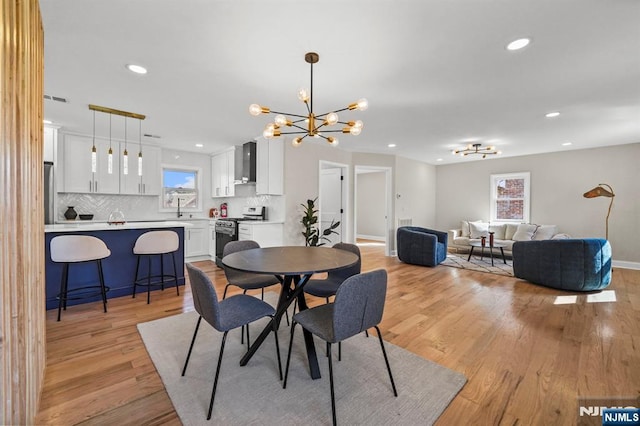 dining room featuring recessed lighting, a chandelier, light wood finished floors, baseboards, and visible vents