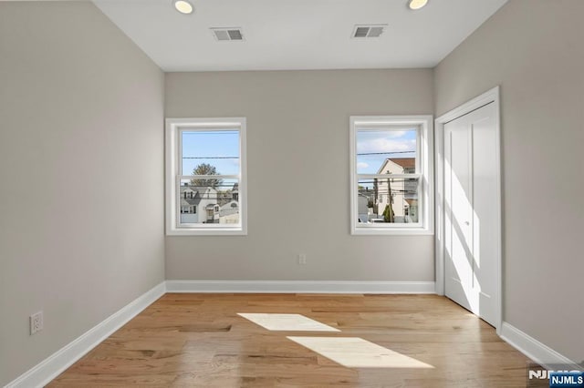 spare room featuring visible vents, recessed lighting, light wood-style flooring, and baseboards