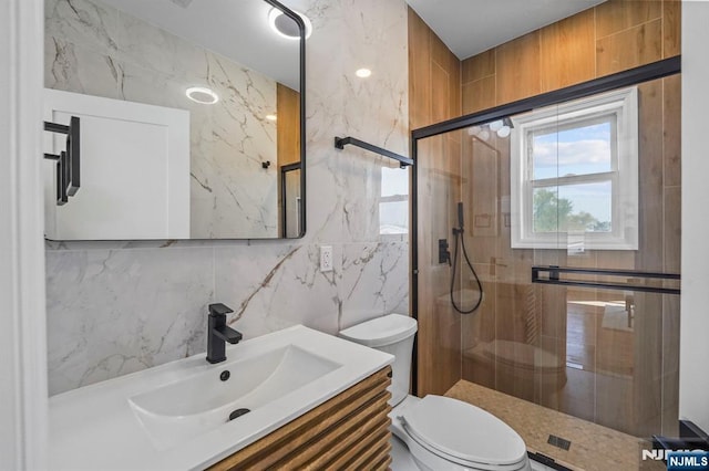 full bath featuring toilet, a stall shower, tile walls, and vanity