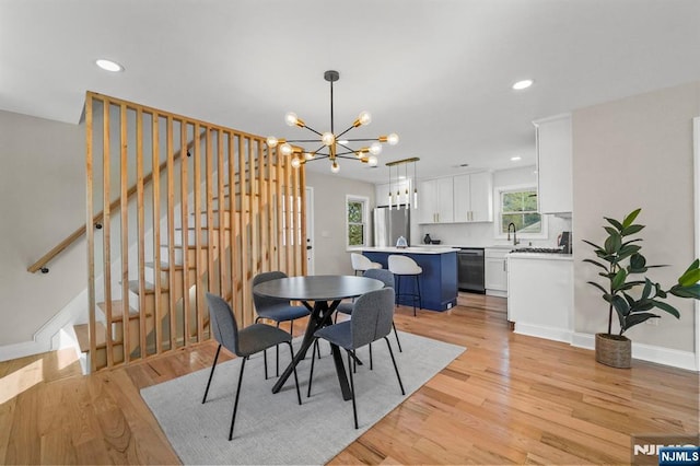 dining space featuring an inviting chandelier, stairway, recessed lighting, and light wood finished floors