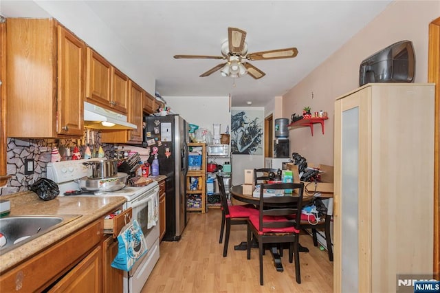 kitchen featuring ceiling fan, white range with electric cooktop, light wood-type flooring, stainless steel fridge with ice dispenser, and under cabinet range hood