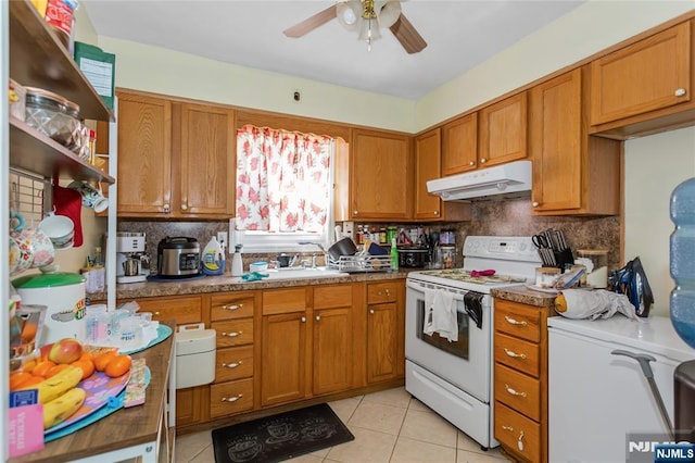kitchen featuring brown cabinets, electric range, ceiling fan, light tile patterned floors, and under cabinet range hood