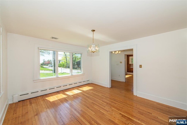 unfurnished room featuring baseboards, a notable chandelier, baseboard heating, and light wood-type flooring