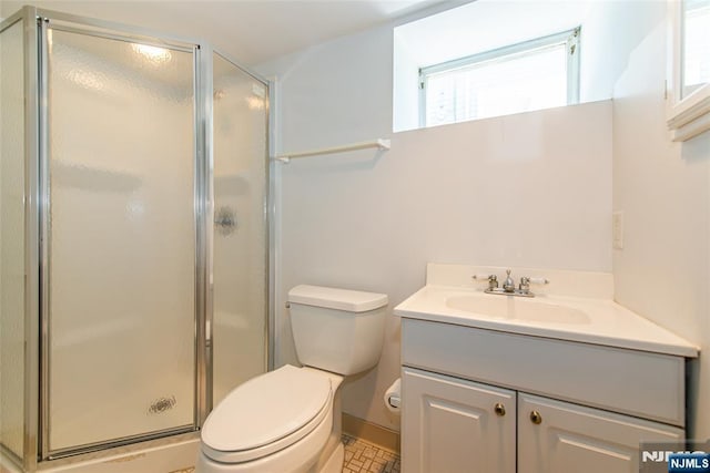 bathroom with vanity, a stall shower, and toilet