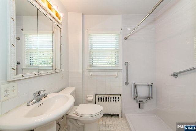 bathroom with plenty of natural light, a sink, walk in shower, and radiator heating unit