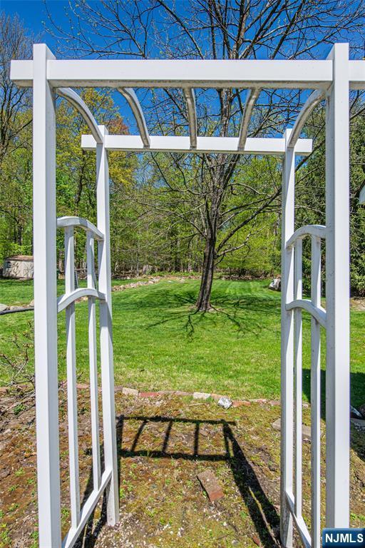 view of gate with a lawn