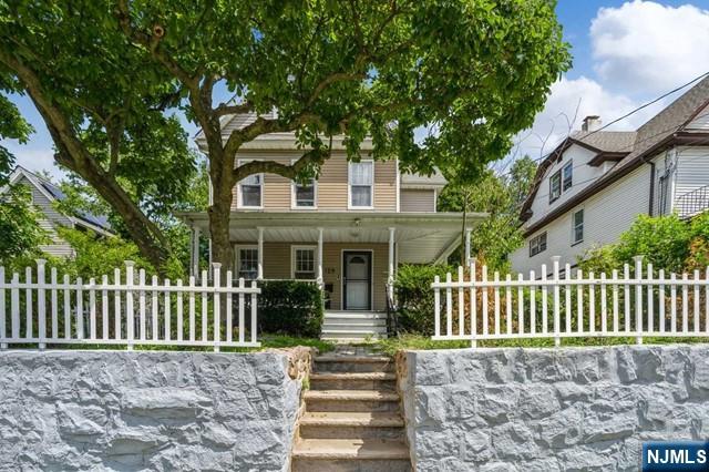 view of front of house with covered porch and a fenced front yard