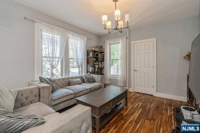 living room with a notable chandelier, wood finished floors, and baseboards