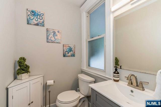 half bathroom with toilet and vanity