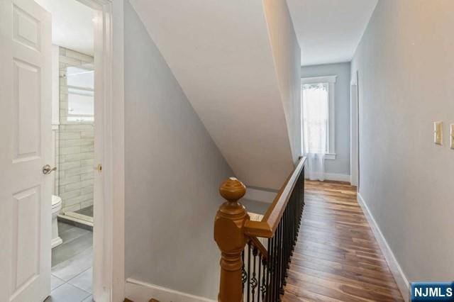 stairs with wood finished floors and baseboards