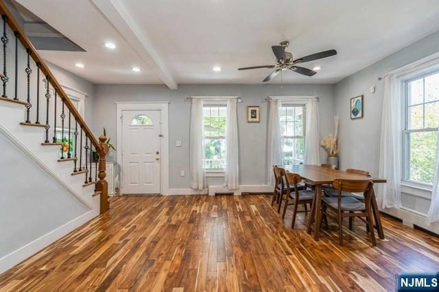 dining room featuring baseboards, stairway, wood finished floors, and a ceiling fan