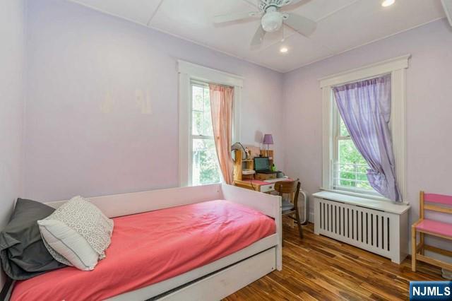 bedroom featuring recessed lighting, ceiling fan, radiator heating unit, and wood finished floors
