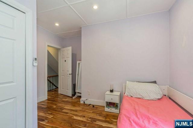 bedroom featuring wood finished floors, recessed lighting, and baseboards