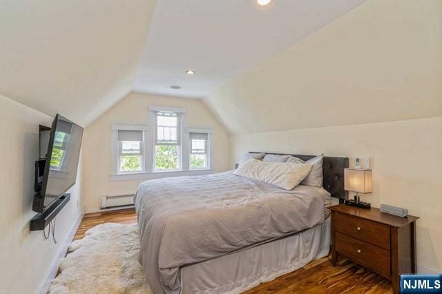 bedroom featuring a baseboard radiator, wood finished floors, recessed lighting, and vaulted ceiling